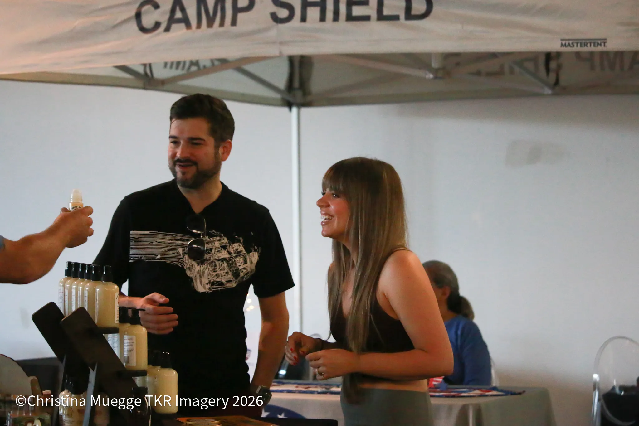 Vendor sharing a product sample with smiling guests during an event