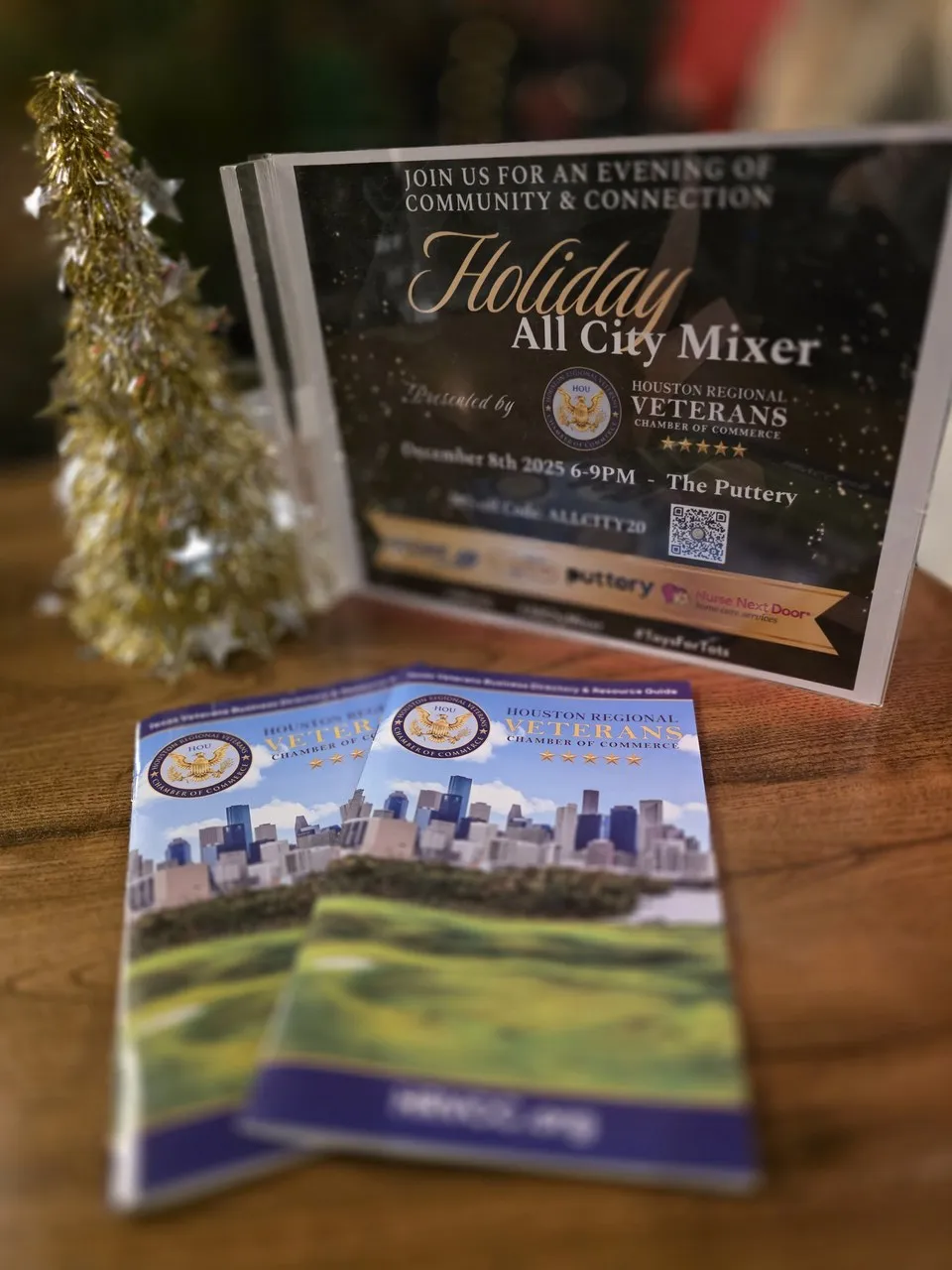 Holiday mixer event signage with sponsor branding and festive decorations
