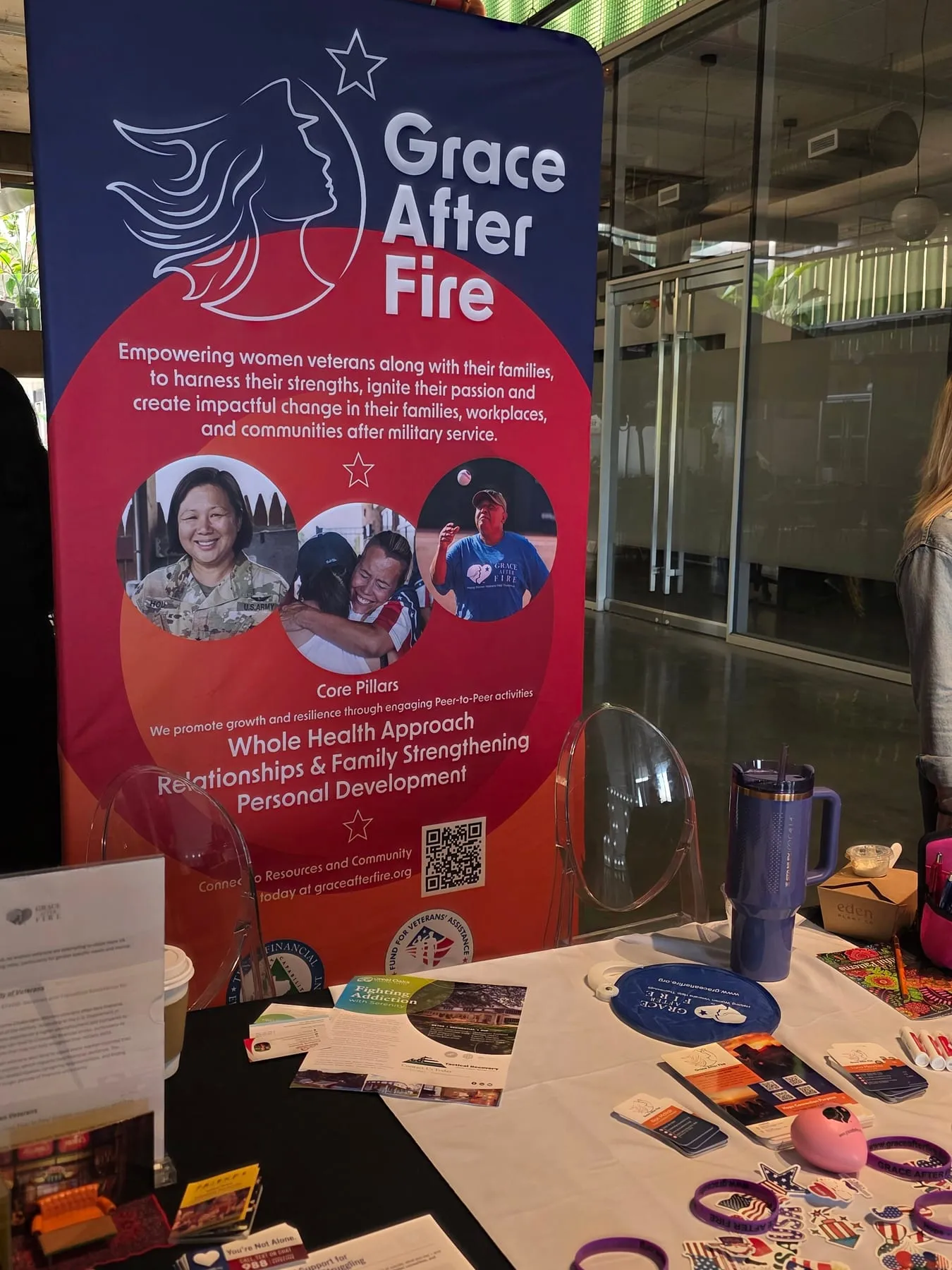 Veteran support organization display table with branded banner and event materials