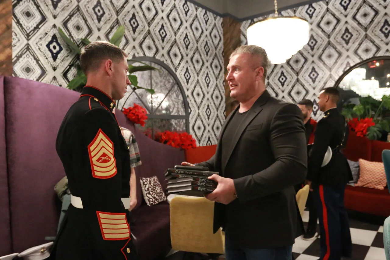 Marine speaking with an attendee during an indoor business gathering