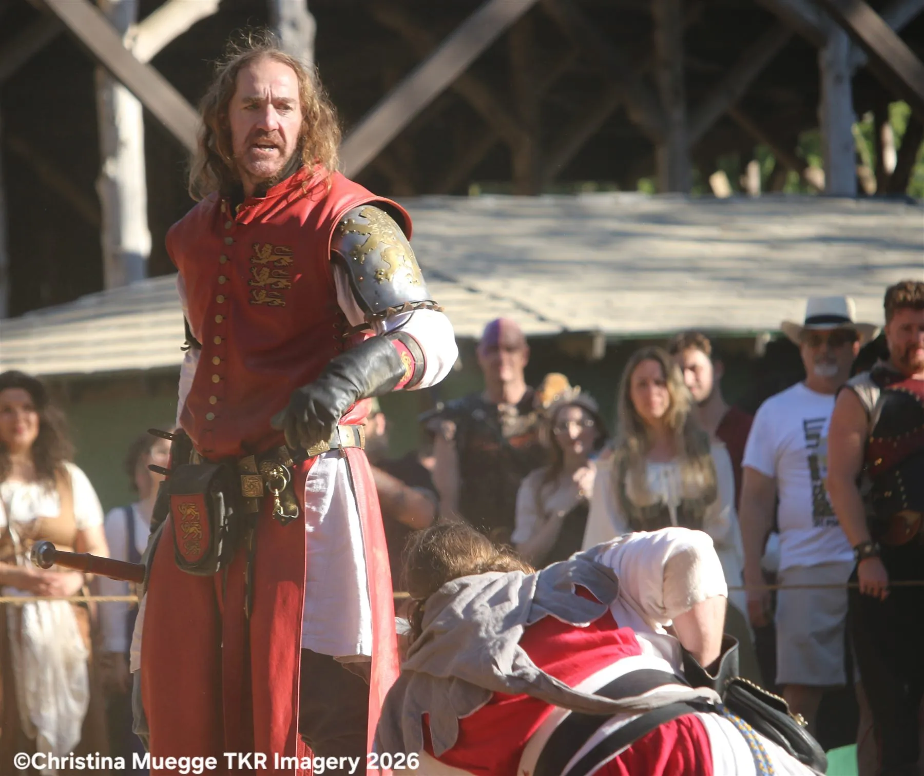 Red knight performer standing after a Renaissance festival action scene