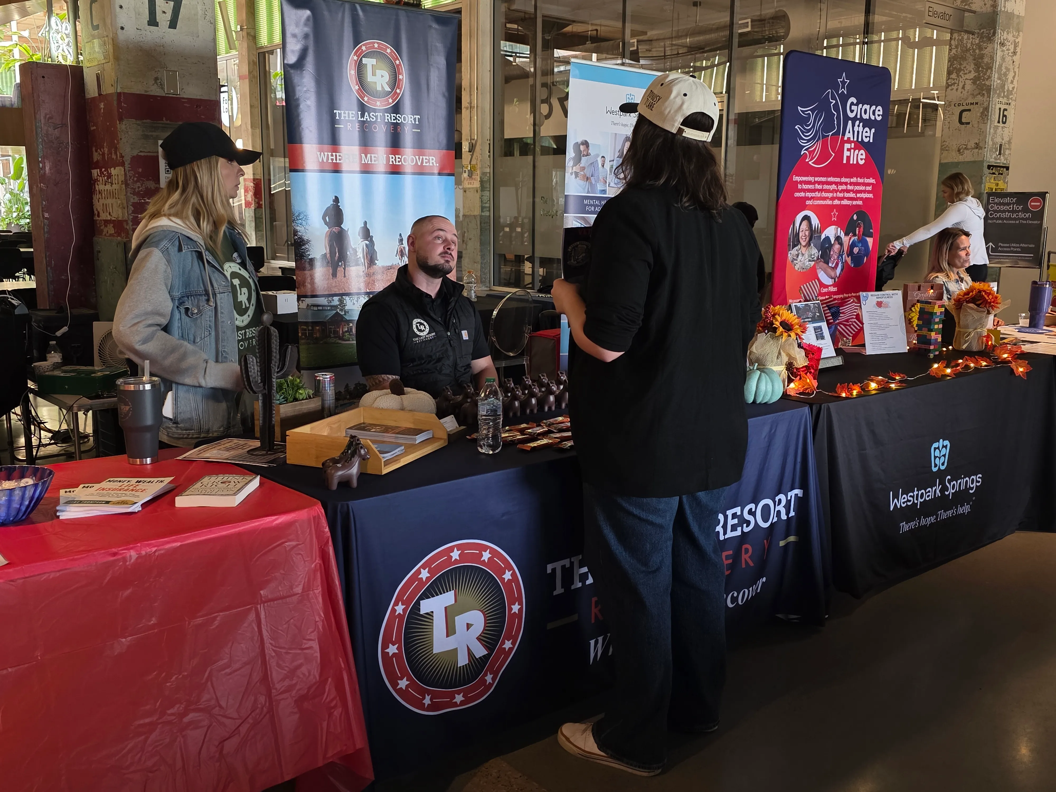 Community event vendors, sponsor tables, and guests during a business event
